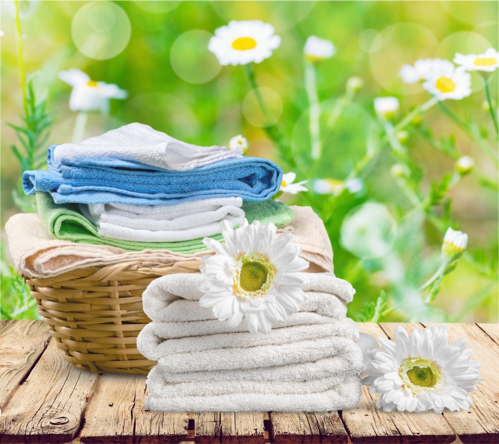 Clean folded towels on a wood table in the meadow