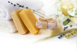 Handcrafted herbal soap bars with folded towels and natural ingredients.