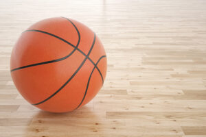 Basketball on gym floor.